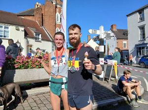 Winners Lindsay McCallum (left) and Luke Maskew pose with their medals and winning cupcakes at the finish.