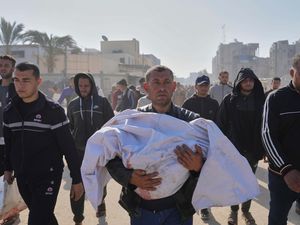 A man carries the body of his nephew who was killed in an Israeli army airstrike