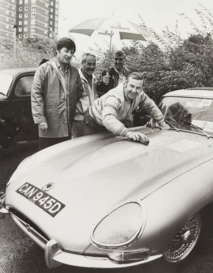 The two-day Dudley Show at Himely Hall had started with overnight and morning rain, after weeks of sunshine, which threatened to turn the grassy areas to mud. The photograph shows Ken Wilson polishing his 1966 E-Type Jaguar, with Alan Jones holding an umbrella, and Frank Lait (left) and Joe Flavell alongside in August 1984.