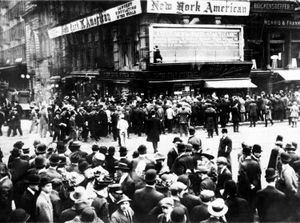 Crowds gather around the bulletin board of a newspaper in New York, where the names of people rescued from the sinking are displayed