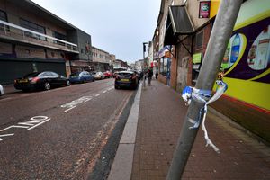 Residual police tape remain attached to post around the area