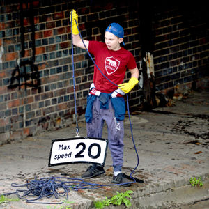 Logan pulls a road sign out the canal