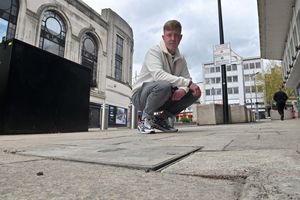 Councillor Simon Bennett examines the uneven pavement in Victoria Street