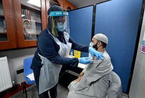Imam of the mosque Muhammad Saeed arrives for his vaccination