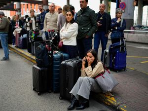 Travellers wait for news about their delayed trains in Madrid