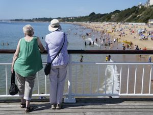 People look out from Bournemouth pier towards Bournemouth beach in Dorset