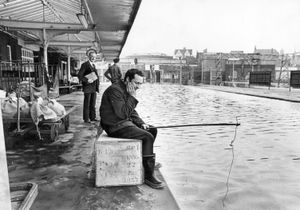 'Waiting for a boat train? Porter Terry Nightingale tries his luck with a hook and line Walsall's flooded railway station in May 1969.'