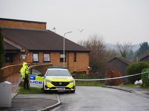 A police officer standing next to a police car