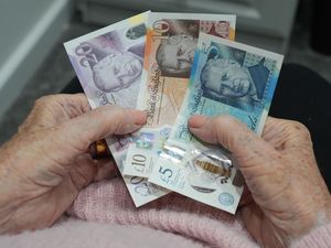 An older woman holding banknotes