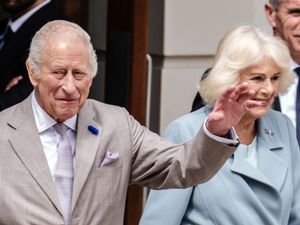 The King and Queen wave to crowds of people