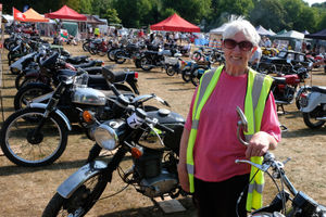 Motorcycle steward Gill Dickerson and the motorbikes on display at the Vintage Show. Image by Andy Compton