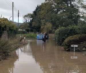 Councillor Kidd visiting the flooded Brookside road during a previous incident.