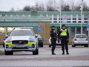 Police officers stand guard near the scene of a shooting at an adult education center on the outskirts of Orebro