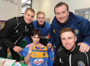 Shrewsbury Town players James Collins, Mark Halstead, Jordon Clark and Manager Micky Mellon give a shirt to Sophie Morgan-Harrison aged 10 during their visit to the Princess Royal Hospital in Telford.