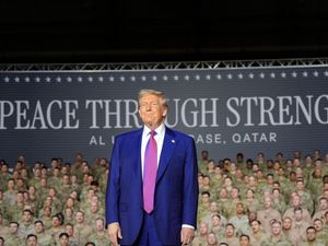 US president Donald Trump stands on stage at the Al Udeid Air Base