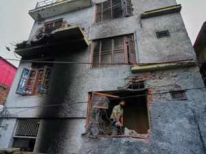Man stands in the window of a scorched building