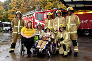 Charlie in his uniform with firefighters and Rays of Sunshine member.