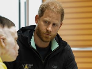 Prince Harry poses with a person who was wounded in war with Russia at the Superhumans Center, an orthopedic clinic in Ukraine