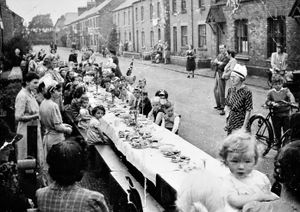 Christine Pemberton, being held by her mother Hilda in the foreground of the picture, was only a few months when these celebrations were held in Station Road, Wem 