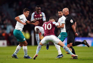 Referee Mike Dean (right) gets in the way of play as Aston Villa's Emiliano Buendia battles for the ball with Manchester City's Riyad Mahrez
