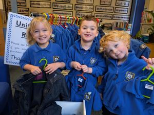 4-year-old Isla Bowen and 3-year-olds George Lewis and Reuben Evans with some of the many items of uniform for sale at Little Trinity Nursery.