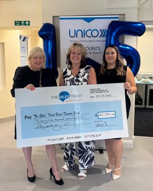 A representative from The Giles' Trust (left) receives cheque for £21,750 from Jane Barker (middle) and Rebecca Dean (right) from Unico 3