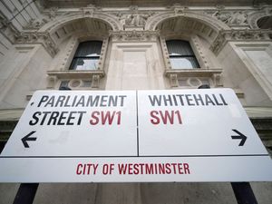 A street sign giving directions to Parliament Street and Whitehall in London