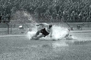 Tom Finney splashes through a puddle on a water-logged pitch