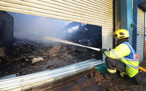 A firefighter helps extinguish the blaze