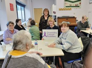Jane Trowbridge holding the sign, Linda Lade behind her with some of the attendees