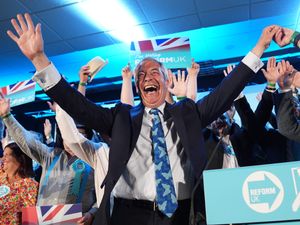 Nigel Farage cheers with Reform UK supporters