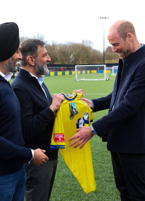 The Prince of Wales is presented with a club shirt during a visit to a referee training course at Sporting Khalsa FC in Willenhall. 