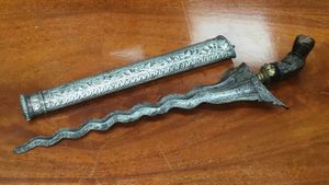 This Malayan kris with silver scabbard was being used as dibber in a garden.