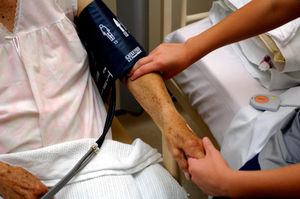 Anurse taking the blood pressure of an elderly patient at an NHS hospital in England.