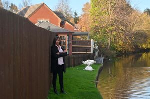 Lynne Jefferson outside the home of her elderly parents. She is concerned after boats have damaged the fragile wooden edge to the canal by spraying water onto their garden and property..
 