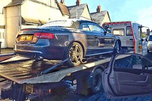An abandoned Audi Cabriolet is taken away on a low loader