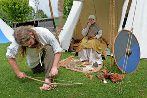 Tim Madden makes fire, watched by Laura Pugh