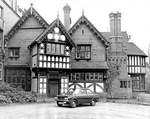 Wightwick Manor, pictured in December 1968, showing the elaborate gables and timbers carved with patterns of Gothic design. The car is a Sunbeam Stiletto.
