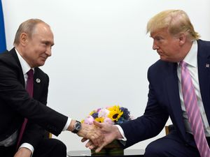 President Donald Trump, (right) shakes hands with Russian President Vladimir Putin