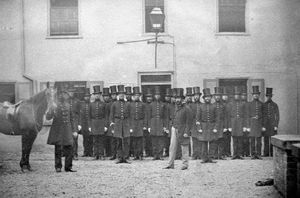 nostalgia pic. Shrewsbury. 'Shropshire County Constabulary in 1859. Captain Crampton, Chief Constable, 1859 to 1864.' Exact location of picture uncertain but may be the old county police headquarters in Swan Hill, Shrewsbury. This picture was saved when the police moved out of the headquarters to move to Monkmoor. It has been loaned to us by ex-policeman Roy Quinton of Baschurch (01939) 260759. Policemen. Old policemen. Police uniform. Police uniforms. Shrewsbury police station. Shrewsbury policemen. Victorian policemen. They say policemen donât look the same these days â and hereâs some historic proof.This photo of the old Shropshire County Constabulary dates from 1859 and must be one of the earliest pictures of the long-defunct force. âThe lads in their big stovepipe hats look like a bunch of rogues,â chuckled retired police sergeant Roy Quinton, who has been looking after the picture and is now planning to hand it over to West Mercia Policeâs museum. According to the caption with the picture, one of them â probably the gentleman standing alone at the front â is Captain Crampton, who was Shropshire Chief Constable from 1859 to 1864. Perhaps the photo was taken for posterity when he took up the post. Captain Crampton was from Glastonbury. Like all the shortlisted candidates, he was a former soldier, having served in the 20th Regiment. He was then Deputy Chief Constable of the Somersetshire Constabulary from its formation in 1856 to his appointment to Shropshire in 1859 at the age of 41. The historic photograph was salvaged by Mr Quinton in the turmoil as the police quit the old county police headquarters in Swan Hill, Shrewsbury, to move to Monkmoor. âI think it was in about 1972, and I was the training sergeant, in charge of all the cadets and probationers for the Shrewsbury and Wellington divisions. âWe had a lot of sorting out to do, deciding what should be taken and what could be disposed of. There were whole cellars to be cleaned out. âT