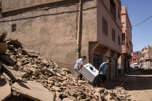 People recover a washing machine from their home that was damaged by the earthquake, in the town of Amizmiz, near Marrakech