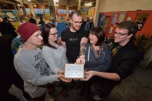 Chris and Bekki Cooper (left) show the plaque in Toby's memory to his brother Zach Wheeler (centre), his mother Shane Game, and his brother Ollie Game.