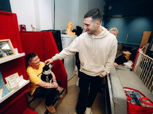 Diogo Dalot, right, pats a dog during a visit to Manchester’s oldest homeless charity