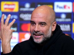 Pep Guardiola raises his hand at a press conference