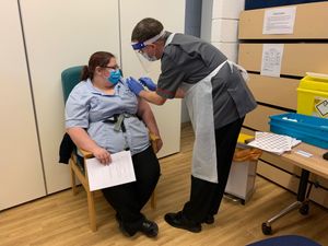 Vicky Hitchens, health care support worker, receiving her Covid vaccination from Dr Ian Turner, deputy chief nurse/director of infection prevention & control