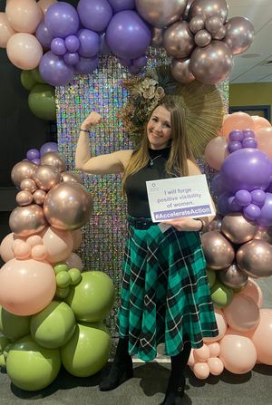 Louise Anne in the International Women's Day 2025 Accelerate Action pose at the Wolverhampton IWD Conference