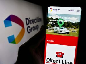 Person holding smartphone with Direct Line Insurance Group web page displayed
