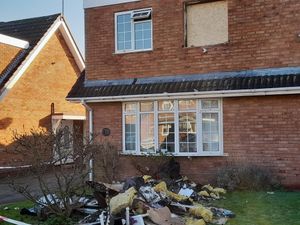 The house showing damaged room and debris in the garden