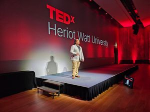 Poggy on stage for their TEDx Talk, 'Engineering Equity with Automation'.