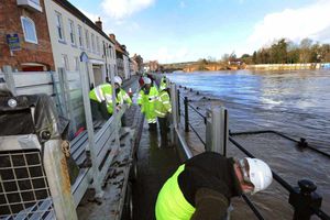 Workers increase the size of the flood barriers